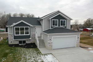 Split level home featuring a front lawn and a garage