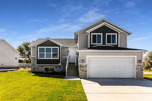 View of front facade with a garage and a front lawn