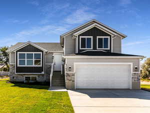 View of front facade with a garage and a front lawn