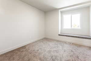 Carpeted empty room featuring baseboards and visible vents