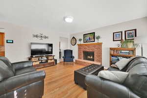 Living room featuring light wood-type flooring and a fireplace