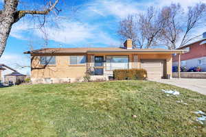 Ranch-style home featuring a front lawn and a garage