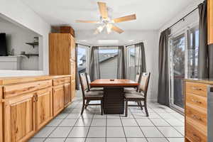 Tiled dining room featuring ceiling fan