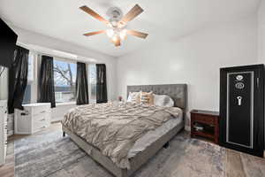 Bedroom with ceiling fan and light wood-type flooring