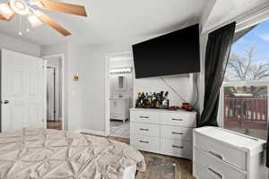 Bedroom featuring ensuite bathroom, heating unit, ceiling fan, wet bar, and light hardwood / wood-style flooring