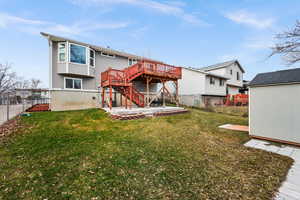 Rear view of house with a lawn, a patio area, a storage shed, and a deck