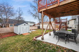 View of yard featuring central AC, a shed, a patio area, and a wooden deck