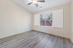 Empty room with ceiling fan and light hardwood / wood-style flooring