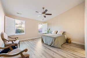 Bedroom featuring light wood-type flooring, vaulted ceiling, and ceiling fan