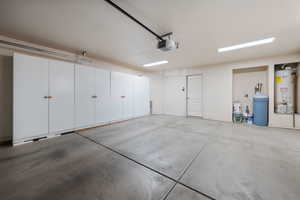 Garage featuring a garage door opener and water heater