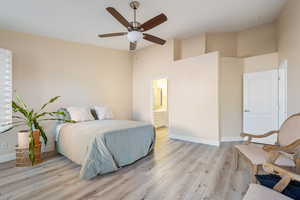 Bedroom featuring ceiling fan, light hardwood / wood-style floors, and connected bathroom