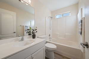 Full bathroom with wood-type flooring, toilet,  shower combination, and vanity