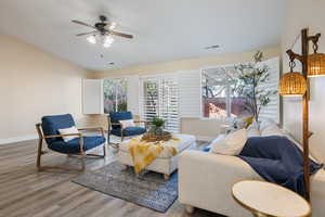 Living room with ceiling fan and hardwood / wood-style floors