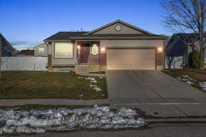 Single story home with a lawn and a garage