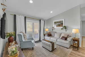 Living room with light wood-type flooring and vaulted ceiling