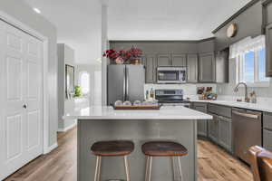 Kitchen featuring a center island, a kitchen bar, sink, and appliances with stainless steel finishes