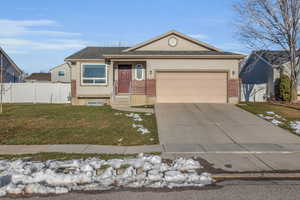 View of front of property with a front yard and a garage