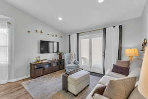 Living room featuring light hardwood / wood-style floors and lofted ceiling