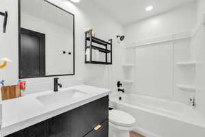 Full bathroom featuring vanity, shower / bathtub combination, and toilet