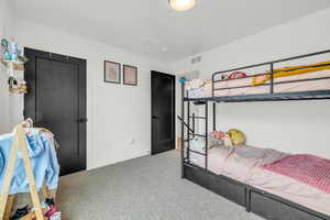 Bedroom featuring light carpet