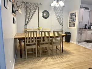 Dining space featuring light hardwood / wood-style flooring, a notable chandelier, and sink