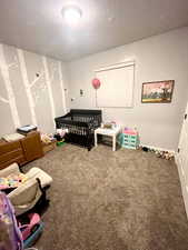 Bedroom with carpet flooring and a crib