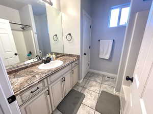 Bathroom with tile patterned flooring, a shower, and vanity