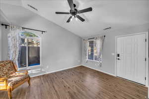 Unfurnished room with ceiling fan, dark wood-type flooring, and lofted ceiling