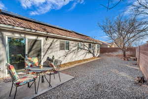 Rear view of house featuring solar panels and a patio