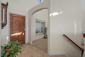 Entryway with light carpet and arch entrance to living room.