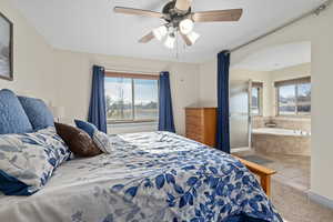 Bedroom featuring ensuite bathroom, ceiling fan, and tile floors