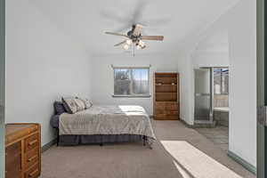 Primary bedroom with ensuite bathroom and ceiling fan