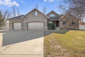 View of front of house featuring a front yard, additional parking, RV parking, and 3 car garage