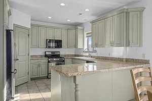 Basement apartment kitchen with stainless steel appliances, granite countertops, pantry, and tile floors.