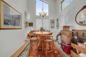 Dining room with a chandelier, a towering ceiling, and hardwood / wood-style flooring