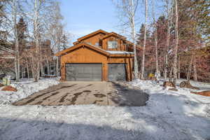 Snow covered property featuring a garage