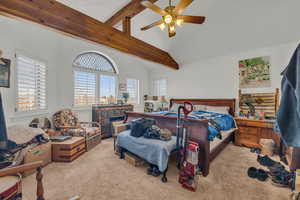 Carpeted bedroom with vaulted ceiling with beams and ceiling fan