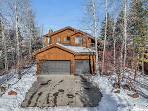 Snow covered property featuring a garage