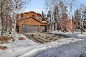 View of snowy exterior with a garage