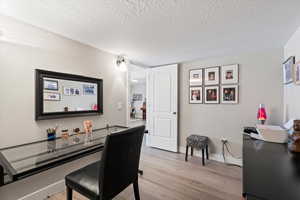 Dining space featuring light hardwood / wood-style floors and a textured ceiling