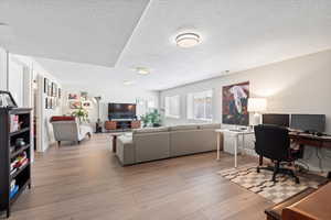 Home office featuring light hardwood / wood-style floors and a textured ceiling