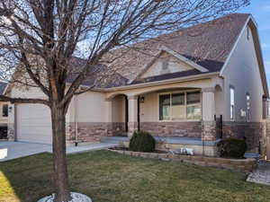 View of front facade featuring a porch, a garage, and a front yard