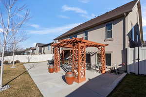 Back of house featuring a lawn, a patio area, and a pergola