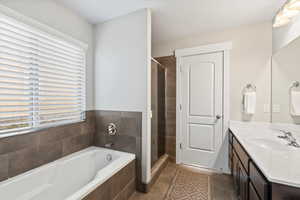 Bathroom with a textured ceiling, vanity, tile patterned floors, and separate shower and tub