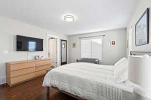 Bedroom featuring a textured ceiling and dark wood-type flooring