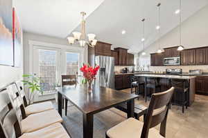 Dining room with plenty of natural light, high vaulted ceiling, and a chandelier
