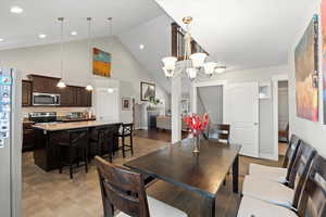 Dining room with high vaulted ceiling and a notable chandelier