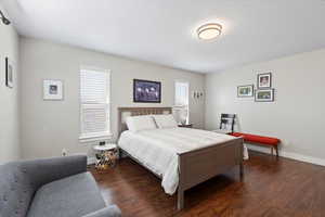 Bedroom featuring a textured ceiling and dark hardwood / wood-style floors