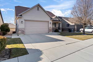 View of front of property featuring a garage and a front lawn