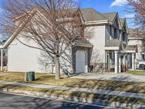 View of front of property with a garage and a front lawn